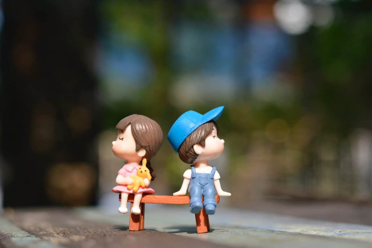 girl and boy figurine on a bench