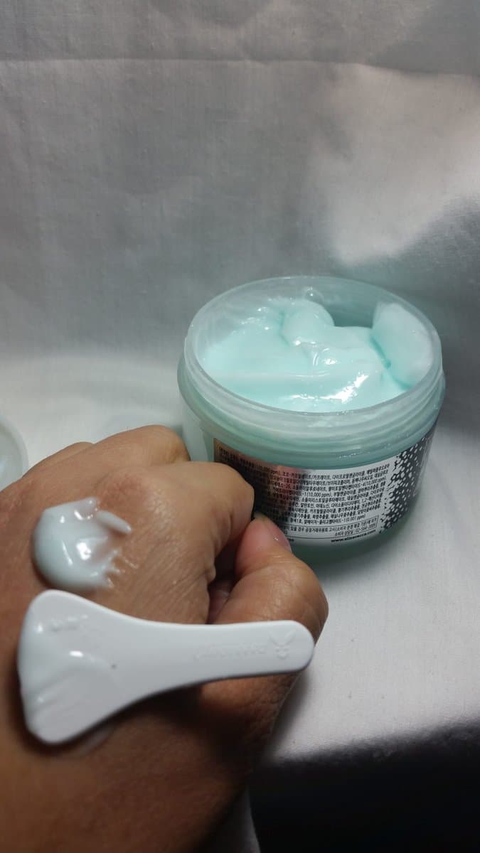 Elizavecca Bubble Facial Cream on my hand. bluish shade with a plastic spatula