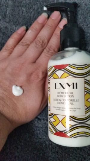 LXMI CRÈME DU NIL BODY LOTION bottle with a spot of lotion on my hand