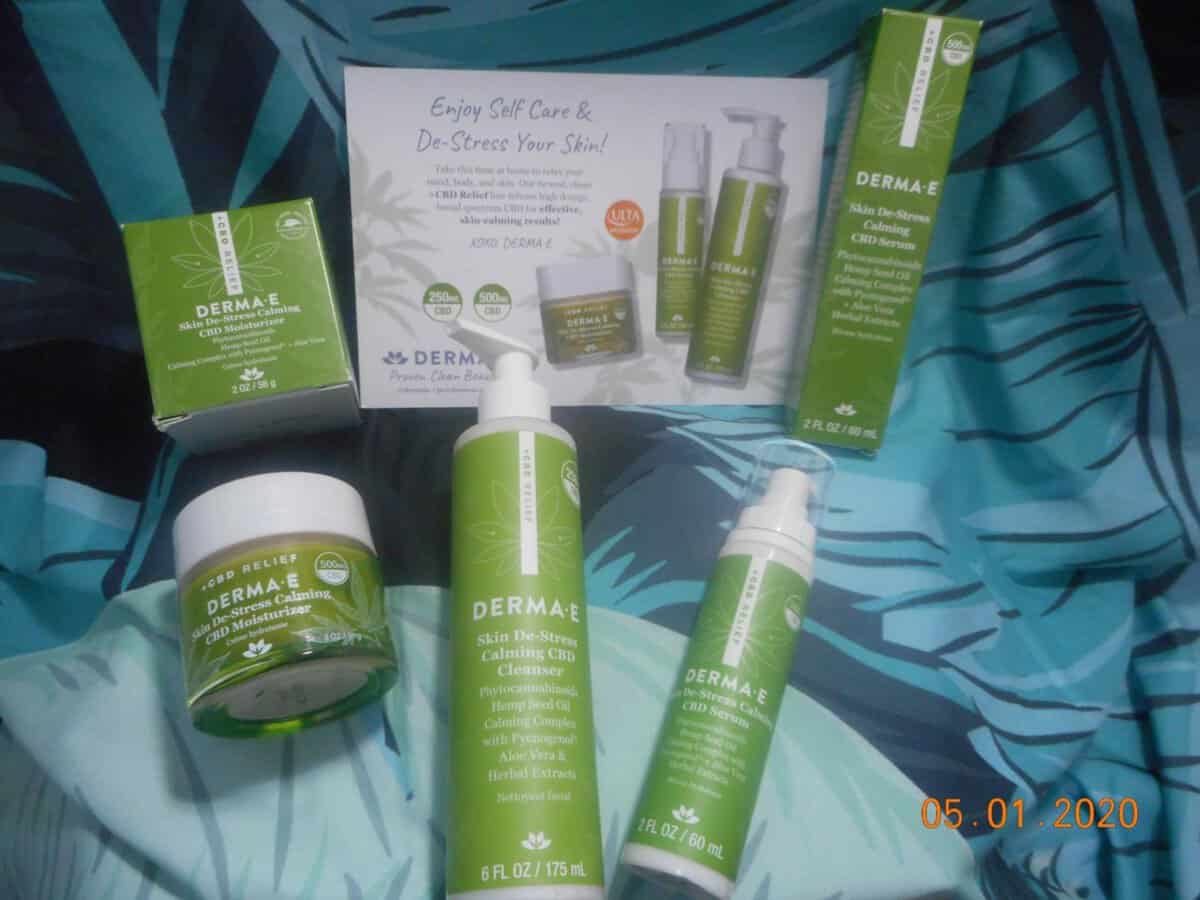 Derma-E CBD collection products left to right skin De-stress claming CBD Moisturizer left Skin De-Stress Calming CBD Cleanser center Skin De-stress calming CBD serum left with moisturizer box Top left product info card center serum box left