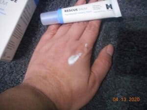 Rescue Balm Post Blemish recovery cream Hero Cosmetics on spread on my hand with tube