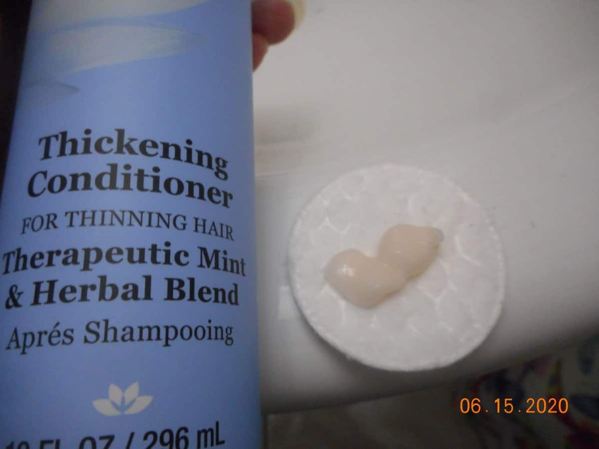 Derma-E Thickening conditioner bottle with conditioner on a cotton pad