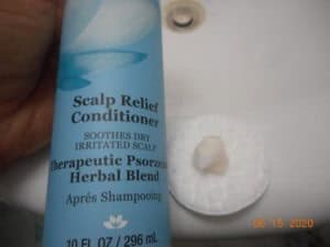 Derma-E Scalp relief conditioner bottle with conditioner on a cotton pad