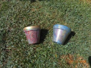 Finished and sealed paint poured pots. left gold with marble. right glitter pot