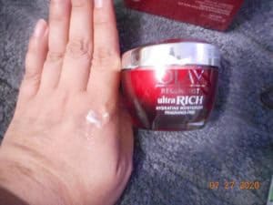 OlayREGENERIST ULTRA RICH MOISTURIZER FRAGRANCE FREE. jar next to my hand. A small amount of product on my hand.