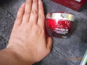 OlayREGENERIST ULTRA RICH MOISTURIZER FRAGRANCE FREE. jar next to my hand. A small amount of product absorbed into my hand.