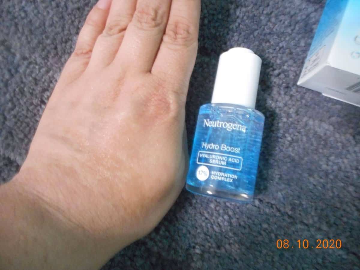 Neutrogena® Hydro Boost Hyaluronic Acid Serum bottle.Bottle next to my hand. Serum on my hand.