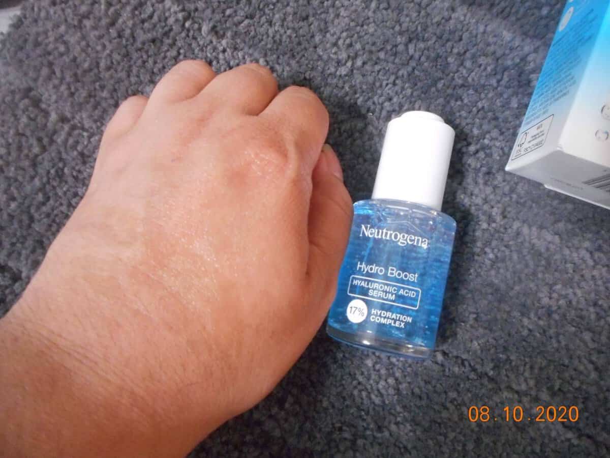 Neutrogena® Hydro Boost Hyaluronic Acid Serum bottle.Bottle next to my hand. Serum absorbed into my hand.