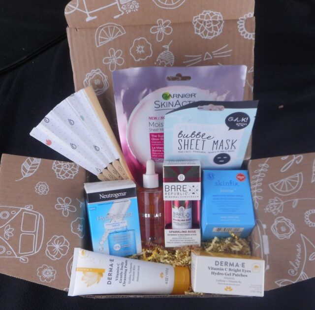 a box filled with skin care products. Serums, sunscreen stick, sheet maks, eye gels, moisurizer, cleanser and a fan.