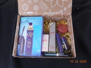 a box filled with beauty products. gift set mascara and primer box, lipsticks, sample face products too.