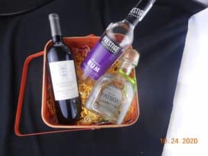 wine, rum and tequila in a basket. basket filled with various colored crinkle paper.