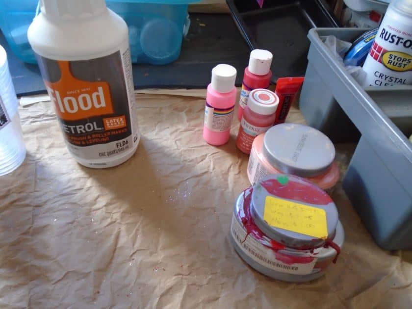 paints in various shades of red, pink and peach. along with Flood floetrol bottle.