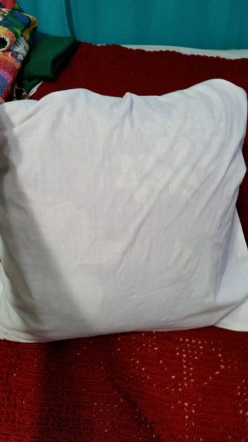 DIY pillow slipcover.square decorative pillow (red) inside of white pillowcase.