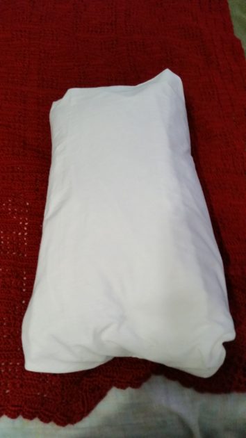 DIY Pillow slipcover. long pillow tucked into white pillowcase.