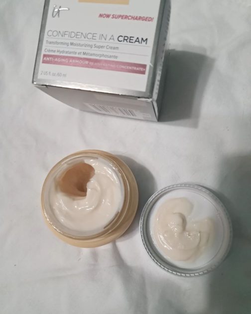 it cosmetics confidence in a cream jar with box. jar has lid removed showing cream colored moisturizer.