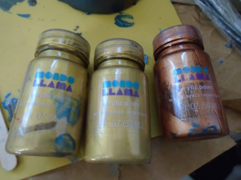 Mondo llama paints 2 gold and 1 copper jars.