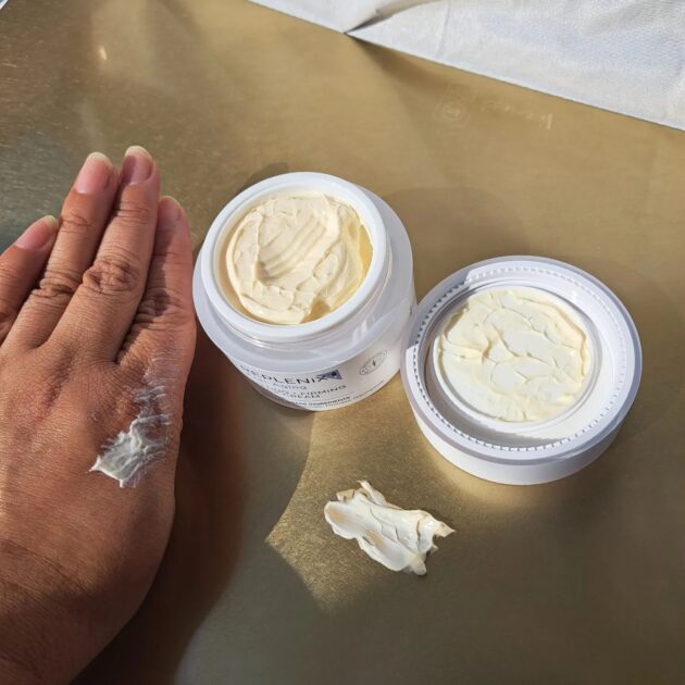 replenix LIFTING + FIRMING NECK CREAM jar opened with two swatches. one on my hand and another on a mat.