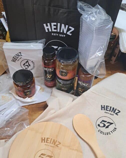 Heinz 57 collection branded tote bag, apron, spoon and cutting board. plastic spoons and tasting trays. Also 3 sauces and 2 honey's.