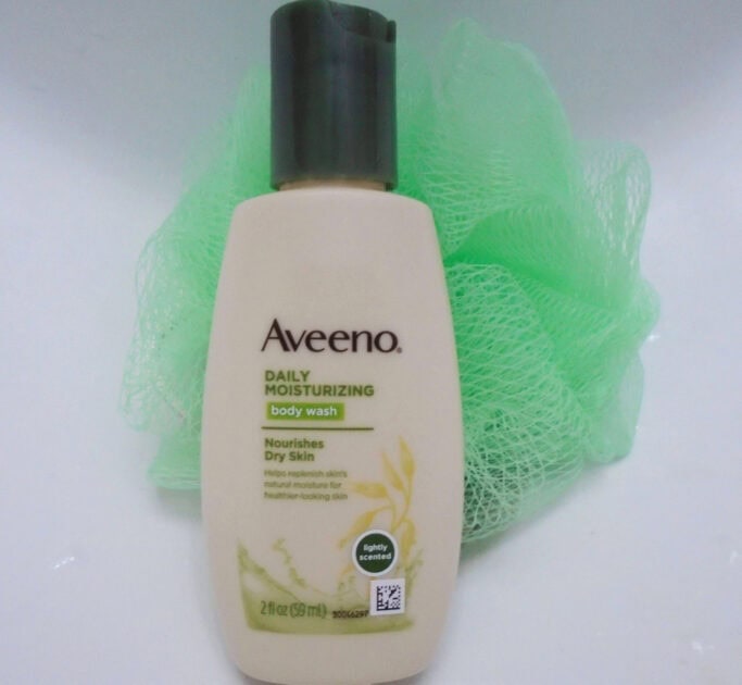aveeno body wash bottle with shower pouf.