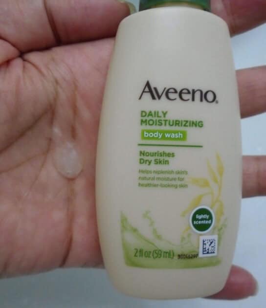 aveeno daily moisturizing body wash bottle with body wash in my hand.