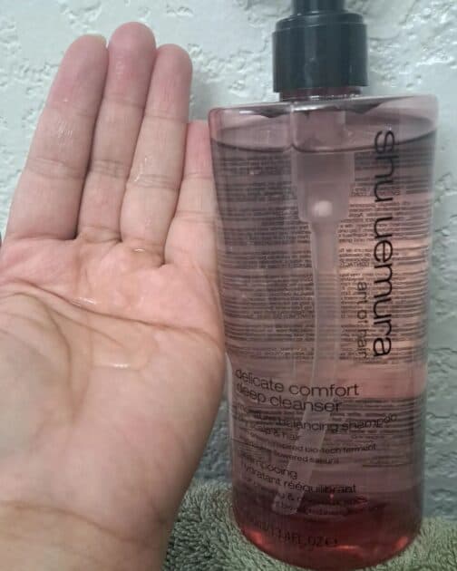 delicate comfort deep cleanser by shu uemura clairfiying shampoo bottle. With shampoo in my hand.