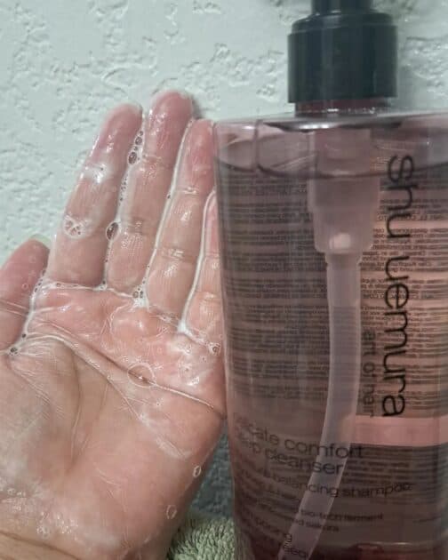 delicate comfort deep cleanser by shu Uemura clarifying shampoo bottle. With shampoo lathered in my hand.