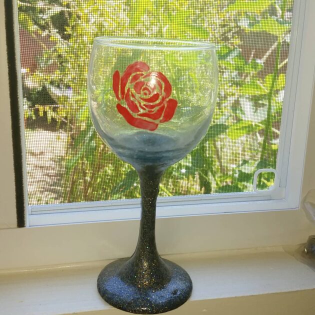 hand painted wine glass. a wine glass with a glitter stem (blue) and red rose.