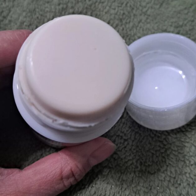 Donna Karan Cashmere mist deodorant stick with plastic protector removed. a soft beige-colored deodorant stick.