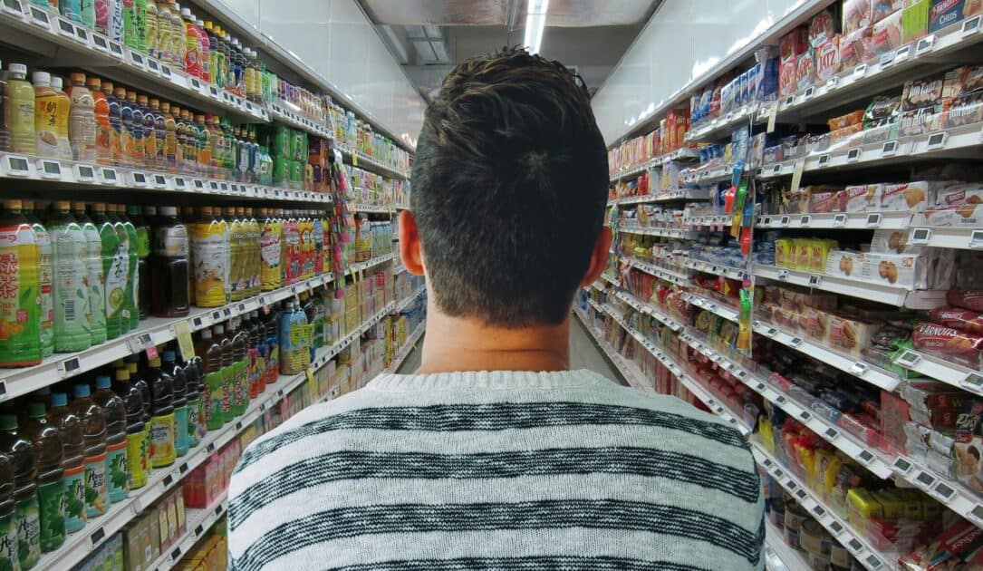 a man standing in a grocery store aisle. image source pixabay dot com.