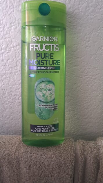 Garnier Fructis Pure Moisture shampoo bottle in natural light. Bright green clear bottle.