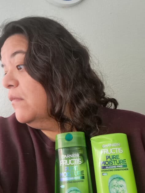 My hair after a few uses of Garnier Fructis pure moisture shampoo and conditioner. Me (V) holding shampoo and conditioner bottles.