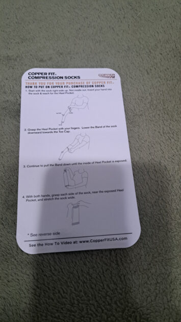 info card on how to put the Copperfit compression socks on front side.