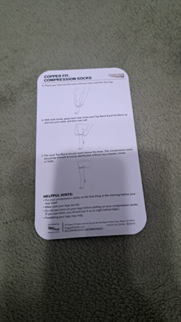 info card on how to put the Copperfit compression socks on back side.