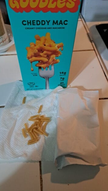 Goodles cheddy mac box with dry pasta and cheese powder packet.