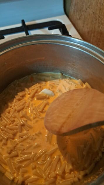 Mixing Goodles cheddy mac cheese powder, milk and butter.