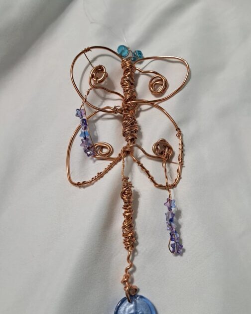 wire butterfly shape with beads attached to wire.