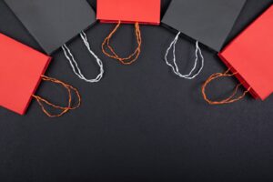 red and black shoppping bags on black background. image from unsplash.