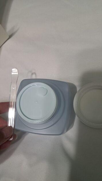 The face shop the therapy vegan mosituere blending cream jar with lid removed. It has a protective lid. image includes spatual as well.