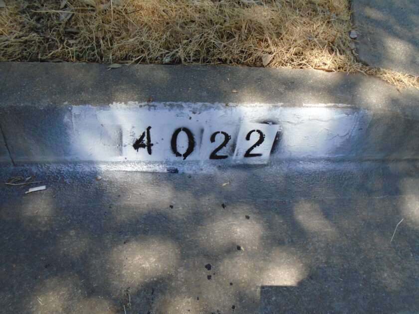 4022 painted on curb in black spray paint on a white background.