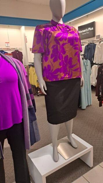 floral blouse fuschia and orange., mannequin weraing a colorful top and black shirt.