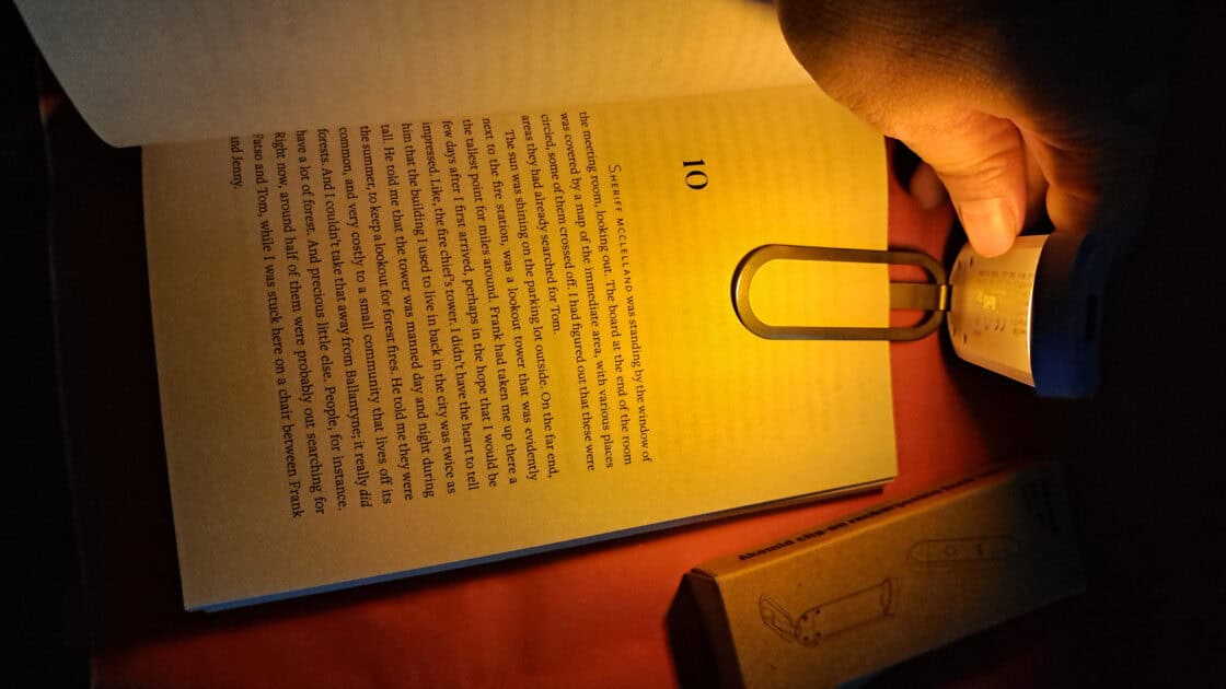 Akomid Book Light light clipped to book. light on warm light.