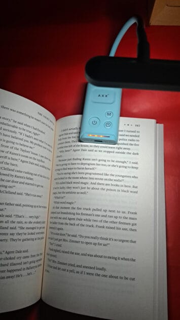 AXX Clip on Book Light clipped to book with light on. power indicator light.