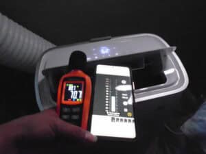 Decibel reader with smartphone on top of a portable AC unit.